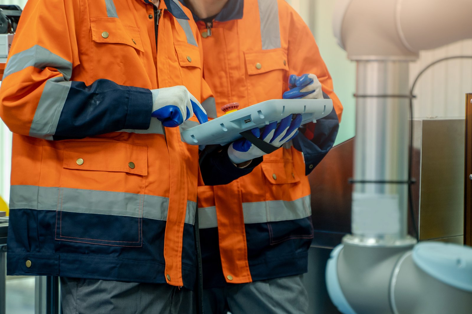 Factory workers using a tablet to manage equipment, part of the fifth industrial revolution Factory workers using a tablet to manage equipment, part of the fifth industrial revolution