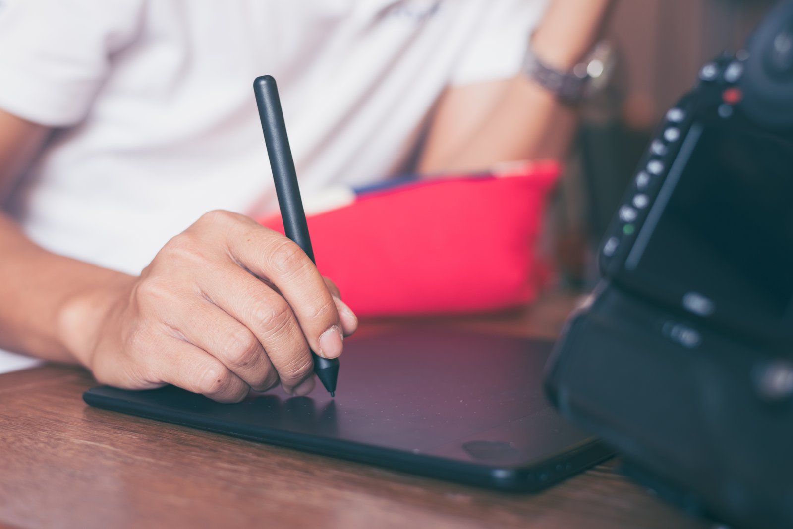A hand drawing with a stylus on a graphics tablet, illustrating AI-assisted design work A hand drawing with a stylus on a graphics tablet, illustrating AI-assisted design work