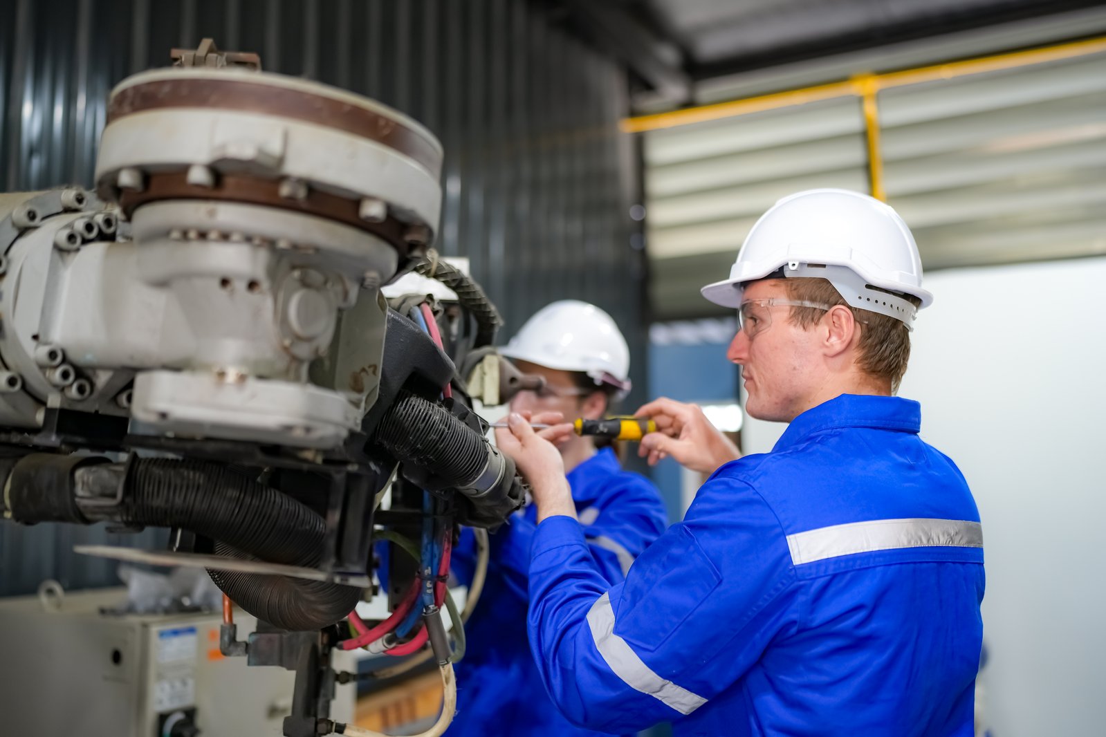 Engineers inspecting and installing industrial equipment during an automation rollout