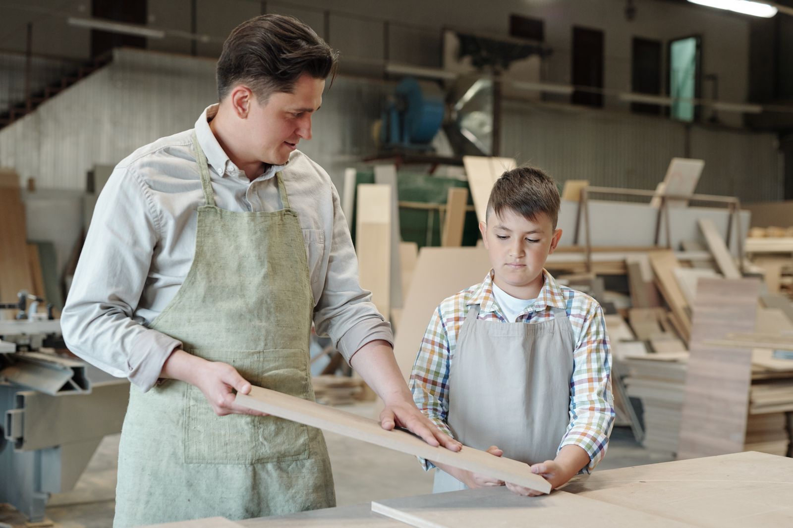 An adult teaching a child woodworking, skills passed down informally within a community