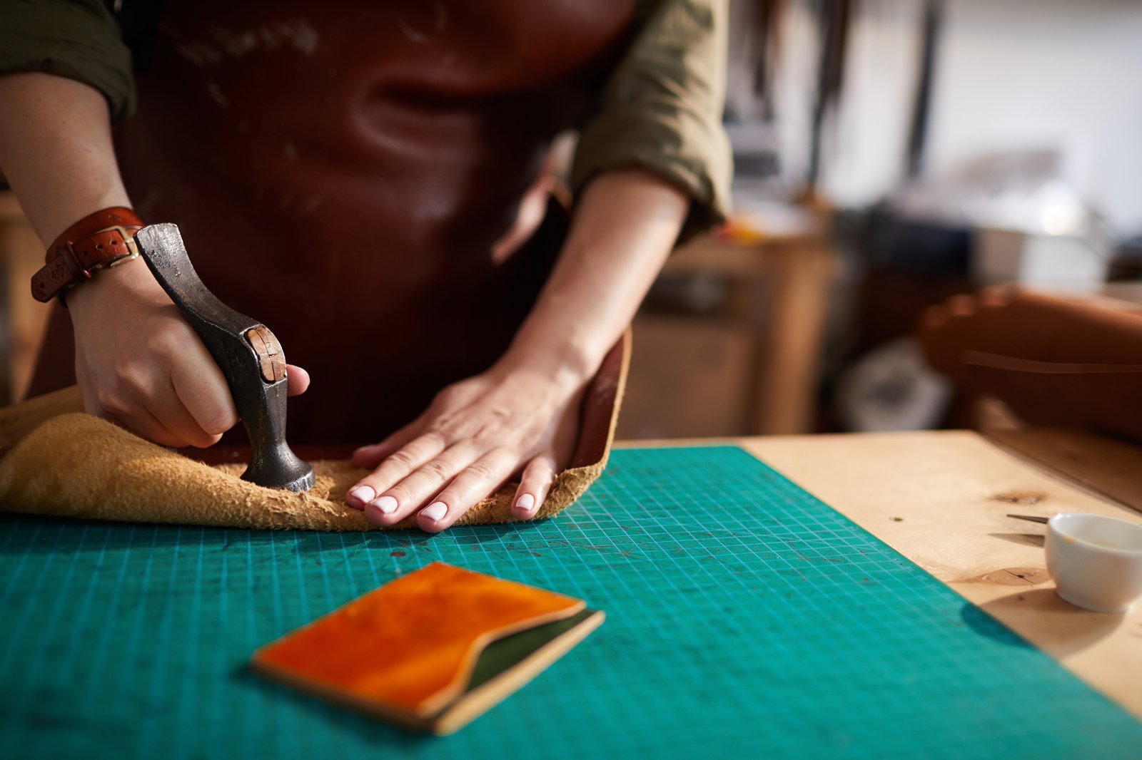A leatherworker hand-crafting a wallet, the kind of detail lost in mass production A leatherworker hand-crafting a wallet, the kind of detail lost in mass production