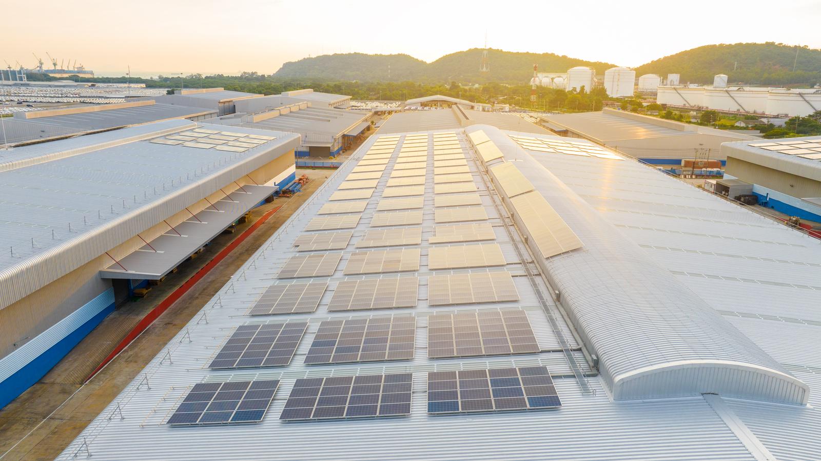 Aerial view of solar panels on a factory roof, illustrating real green manufacturing metrics Aerial view of solar panels on a factory roof, illustrating real green manufacturing metrics