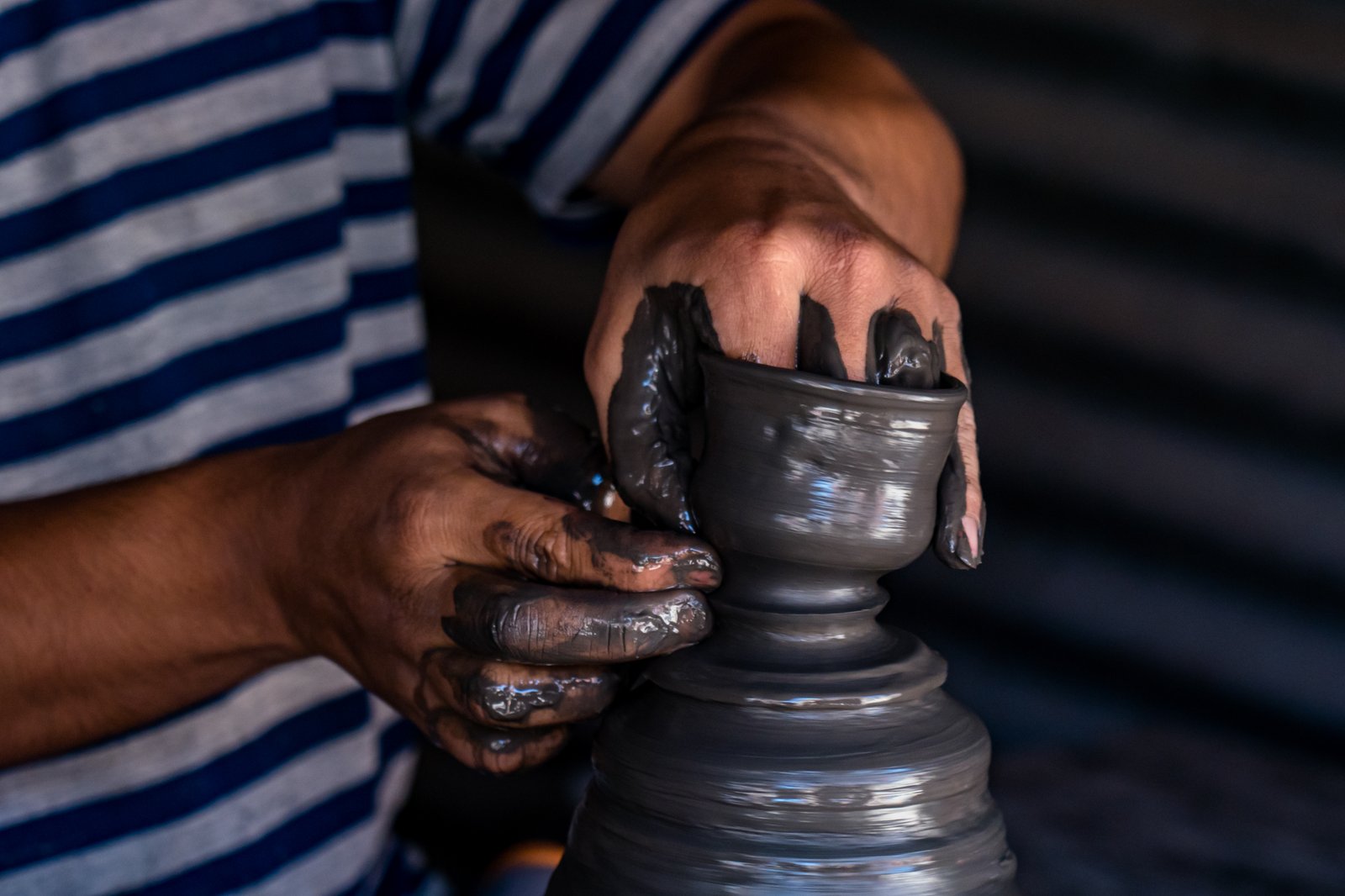 Hands shaping clay pottery, a traditional craft practiced around the world